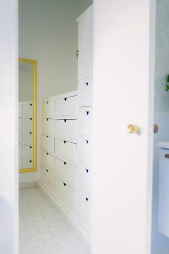 a bathroom with white tiled walls and a mirror at Casa Amma - Chita in Matehuala
