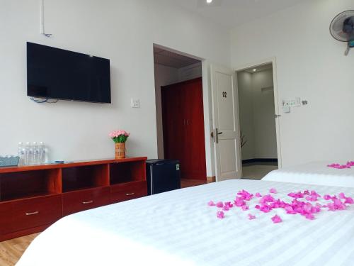 a bedroom with a bed with pink flowers on it at KHÁCH SẠN PHÚ YÊN - Khách sạn ven biển - trung tâm Tuy Hoà in Tuy Hoa