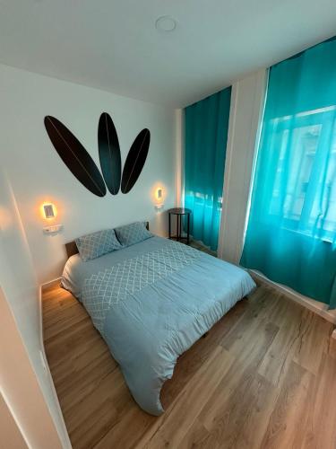 a bedroom with a large bed and a large window at Douro Surf Hostel in Vila Nova de Gaia