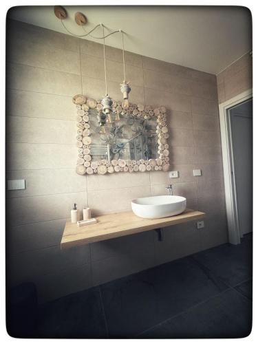 a bathroom with a sink and a mirror on the wall at Appartamento Miro' Fine Living in Alghero