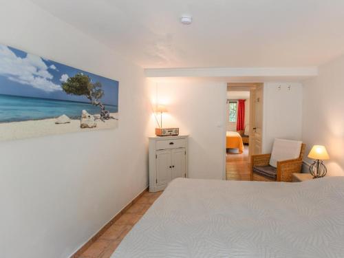 een slaapkamer met een bed en een schilderij aan de muur bij Lou Romarin in Nans-les-Pins