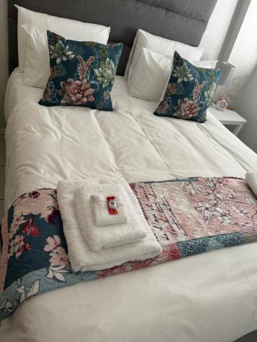 a white bed with a blanket and pillows on it at The Silhouette in Paarl