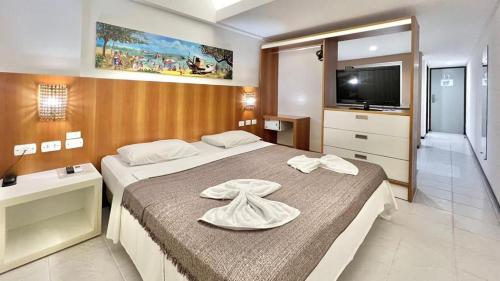 une chambre d'hôtel avec deux lits et une télévision dans l'établissement Apartamento Beira Mar centro Pipa com Piscina vista mar completo, à Pipa