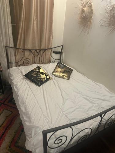 - un lit avec des draps blancs et 2 oreillers dans l'établissement Sacré-Cœur appart atypique, à Paris