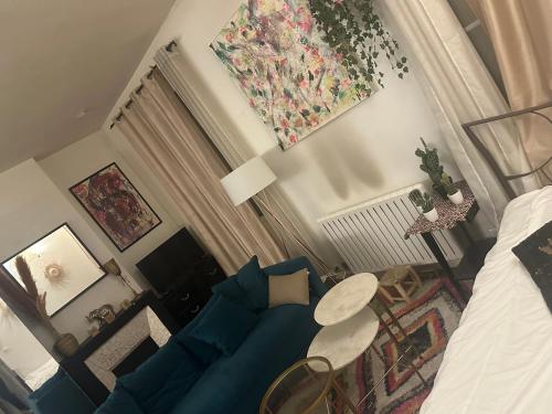 un salon avec un canapé bleu et une table dans l'établissement Sacré-Cœur appart atypique, à Paris