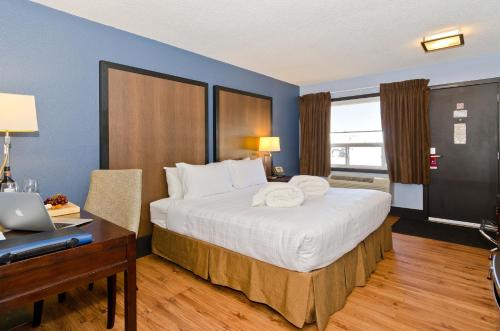a bedroom with a bed with a desk and a laptop at Centro Motel in Calgary