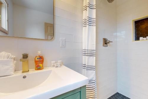 a white bathroom with a sink and a shower at Hytta Hyggelig in Tabernash