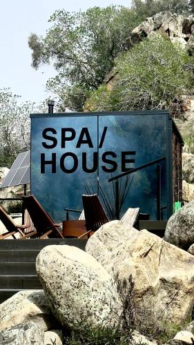 a sign for a spa house next to some rocks at Paradise Ranch Inn - Liberated Tent in Three Rivers