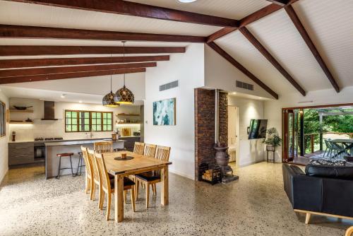 a kitchen and dining room with a wooden table and chairs at Grove Hinterland Retreat - 15 mins to beach in Kiels Mountain