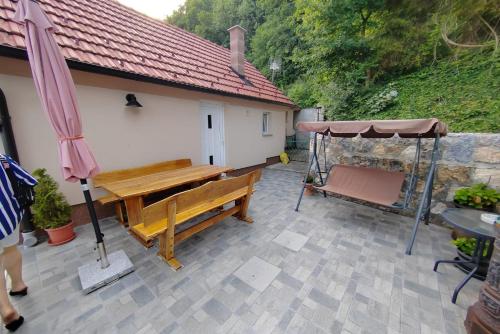 a patio with a wooden bench and an umbrella at Apartments with parking spaces Kalnik, Podravina - 22913 in Križevci