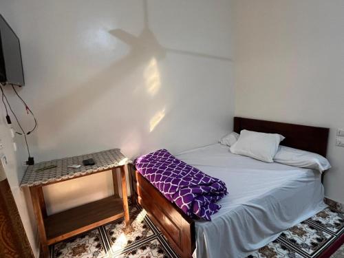 a bedroom with a bed and a cross projected on the wall at Sunset Guesthouse Abusir in Cairo