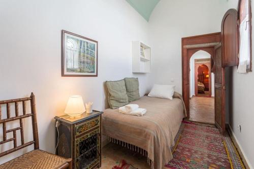 une chambre avec un lit, une table et une lampe dans l'établissement Casa mesana, à Assilah