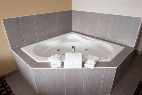 a bath tub with towels in a bathroom at Western Star Inn and Suites Carlyle in Carlyle