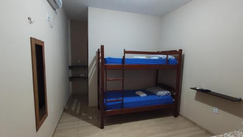 a room with three bunk beds in a room at Casa de temporada 02 -Chalé Portal do Paraíso in Santo Amaro