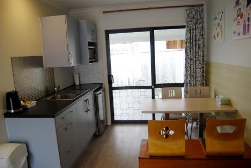 a small kitchen with a table and a window at Energy Motor Lodge Papamoa in Tauranga