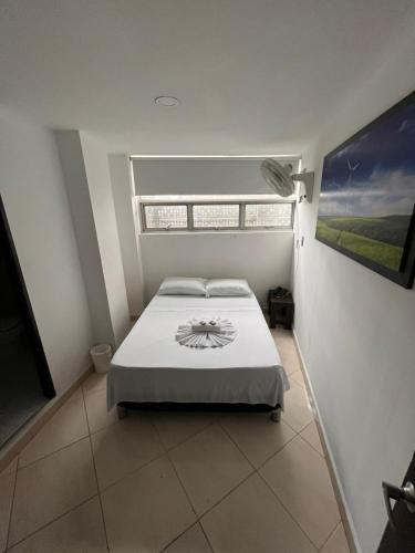 a bedroom with a large bed with a window at Hotel Los Ángeles in Bello