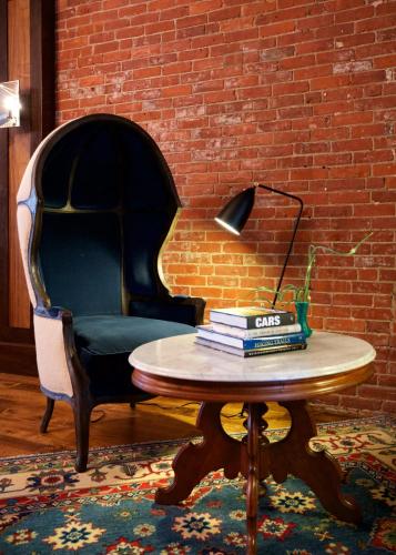 a table and a chair with a lamp and books on it at Hotel on North in Pittsfield
