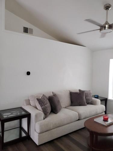 a white living room with a couch and a table at Tara condo in San Antonio