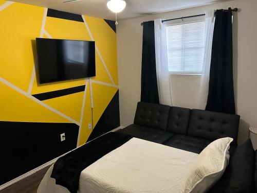 基林的住宿－Cozy5star，一间卧室配有一张床,墙上配有电视