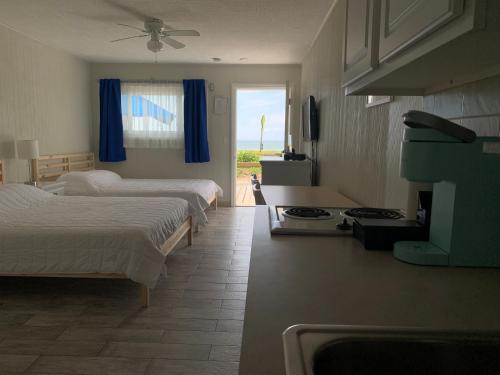 1 Schlafzimmer mit 2 Betten und einem Herd in der Unterkunft Southold Beach Motel in Southold