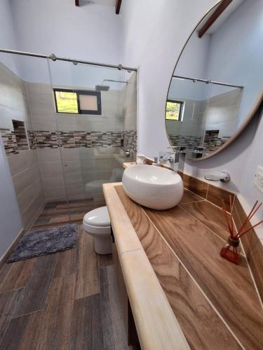 a bathroom with a sink and a mirror at Casa Bella Guatapé acceso directo a la represa in Guatapé