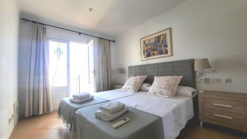 a bedroom with a large bed with towels on it at Can Alou, Village House With Mediterranean Charme in Felanitx