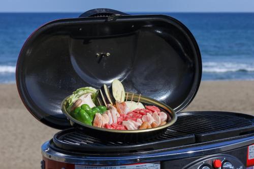 a grill with a plate of meat and vegetables at Hotel NALU　ホテルナル in Kannoura