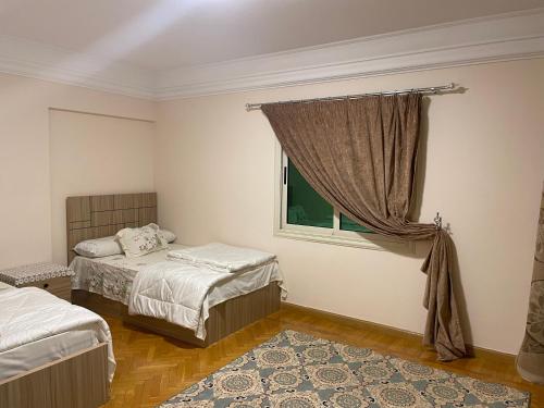 une chambre avec deux lits et une fenêtre dans l'établissement لؤلؤه ابراج الخليج, au Caire