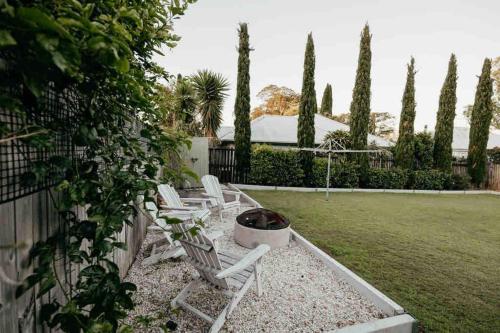 a group of chairs sitting in a yard at Cosy Country Cottage in Alstonville