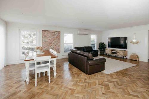 a living room with a couch and a table at Cosy Country Cottage in Alstonville