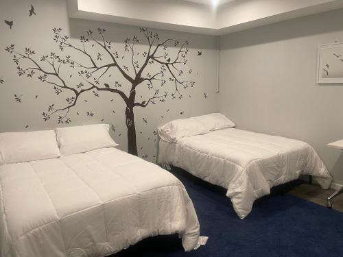 a bedroom with two beds and a tree on the wall at Luxury Mountain Home in Huntingdon