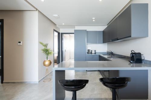 a kitchen with a counter and two stools at Atlantic View Appart'Hotel in Casablanca