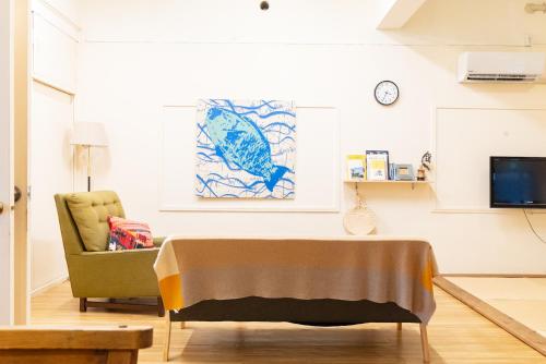 a living room with a table and a chair at Pineapple Hotel in Naha