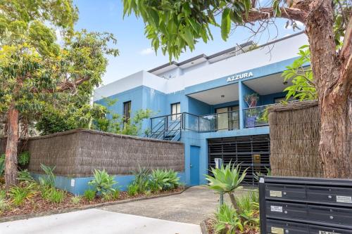 a blue house with a fence and trees at Chic Brookvale Unit-Big Balcony! in Sydney