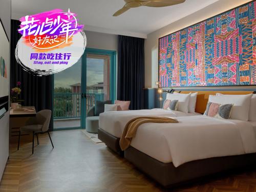 シンガポールにあるResorts World Sentosa - Hotel Oraの大きなベッドと看板が備わるホテルルームです。