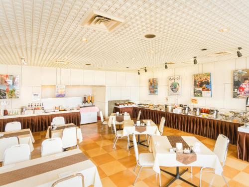 a restaurant with tables and chairs and a counter at Yatsushiro Grand Hotel in Yatsushiro
