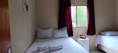 a small bedroom with a bed and a window at Pousada Flor de Pitaya in Viçosa do Ceará