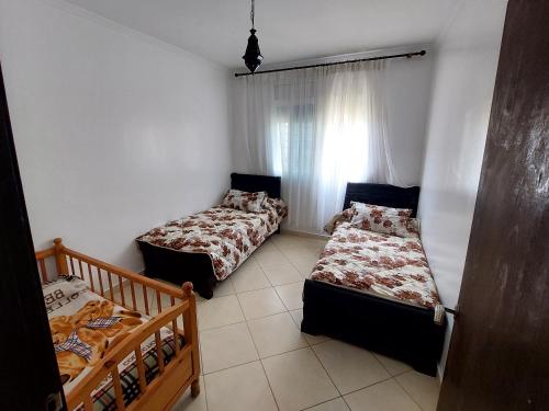 a bedroom with two beds and a window at Nador Holidays in Nador