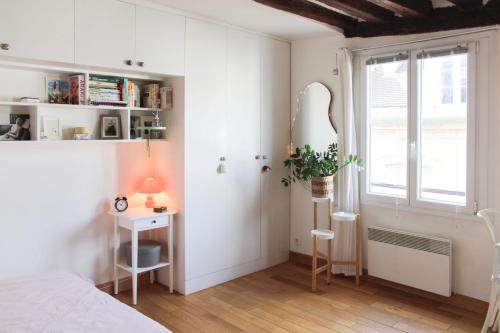 une chambre avec un lit, un bureau et une fenêtre dans l'établissement Bright and quiet 25 m apartment, à Paris
