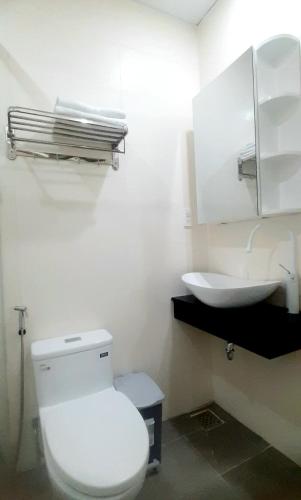 a bathroom with a white toilet and a sink at C - Home in Can Tho