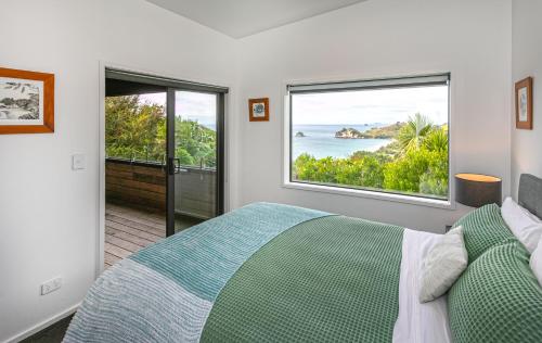 a bedroom with a bed and a view of the ocean at Cathedral cove and Sunrise in Hahei