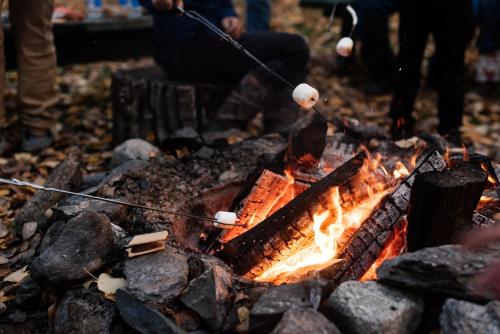 a person is cooking food on a campfire at Alaska Cozy Cabins in Wasilla