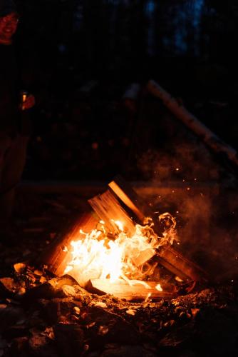 a bonfire in the woods at night with flames at Alaska Cozy Cabins in Wasilla