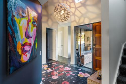 a hallway with a colorful painting on the wall and a staircase at Beacon Point Retreat by Sotheby's Luxury Rental Homes in Wanaka