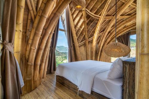 ein Schlafzimmer mit einem Bett und einem großen Fenster in der Unterkunft Villa Grazia - Anima Eco Lodge -Ville Lussuose con Piscina Vista Mare in Selong Belanak