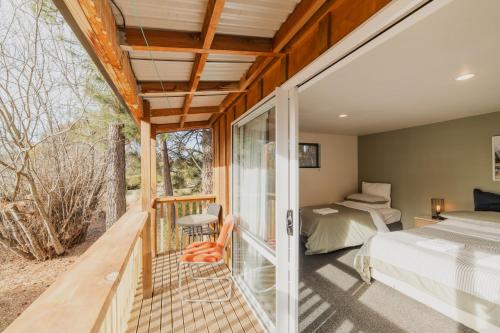 ein Schlafzimmer mit einem Bett und einem Balkon in der Unterkunft Lake Tekapo Cottages in Lake Tekapo