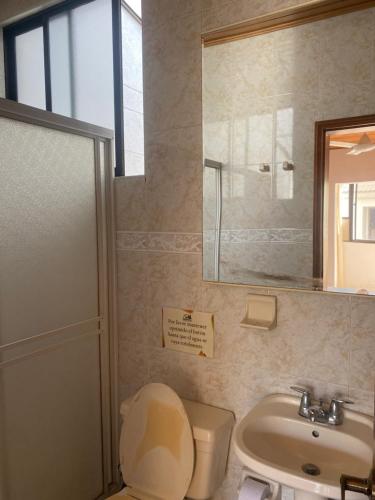 a bathroom with a toilet and a sink and a mirror at Paraiso Pie de la Popa in Cartagena de Indias