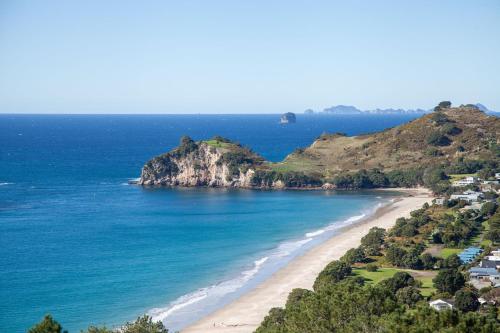 a view of a beach with houses and the ocean at Cathedral cove and Sunrise in Hahei