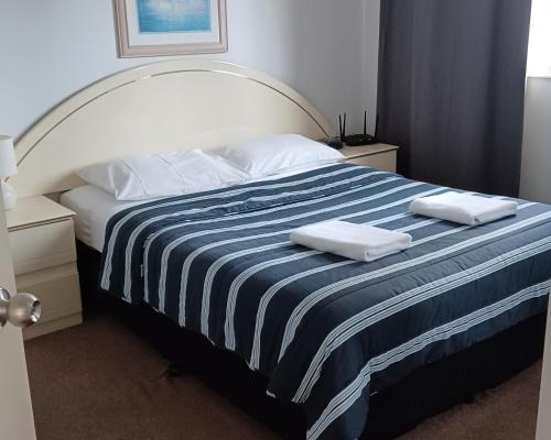 a bedroom with a bed with two towels on it at Blue Waters Apartments in Gold Coast