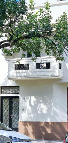 a white building with a tree in front of it at Nelly's Apartment in Buenos Aires